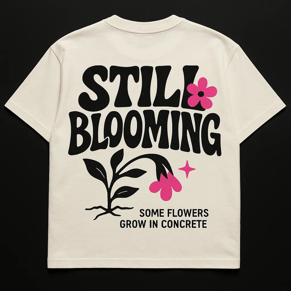Example output from the Minimal Concept T Shirt Back Prints ChatGPT prompt: premium flat-lay T-shirt mockups with bold centered quotes, minimalist concept icons, vivid highlights, and high-resolution fabric texture rendering. Still Blooming.