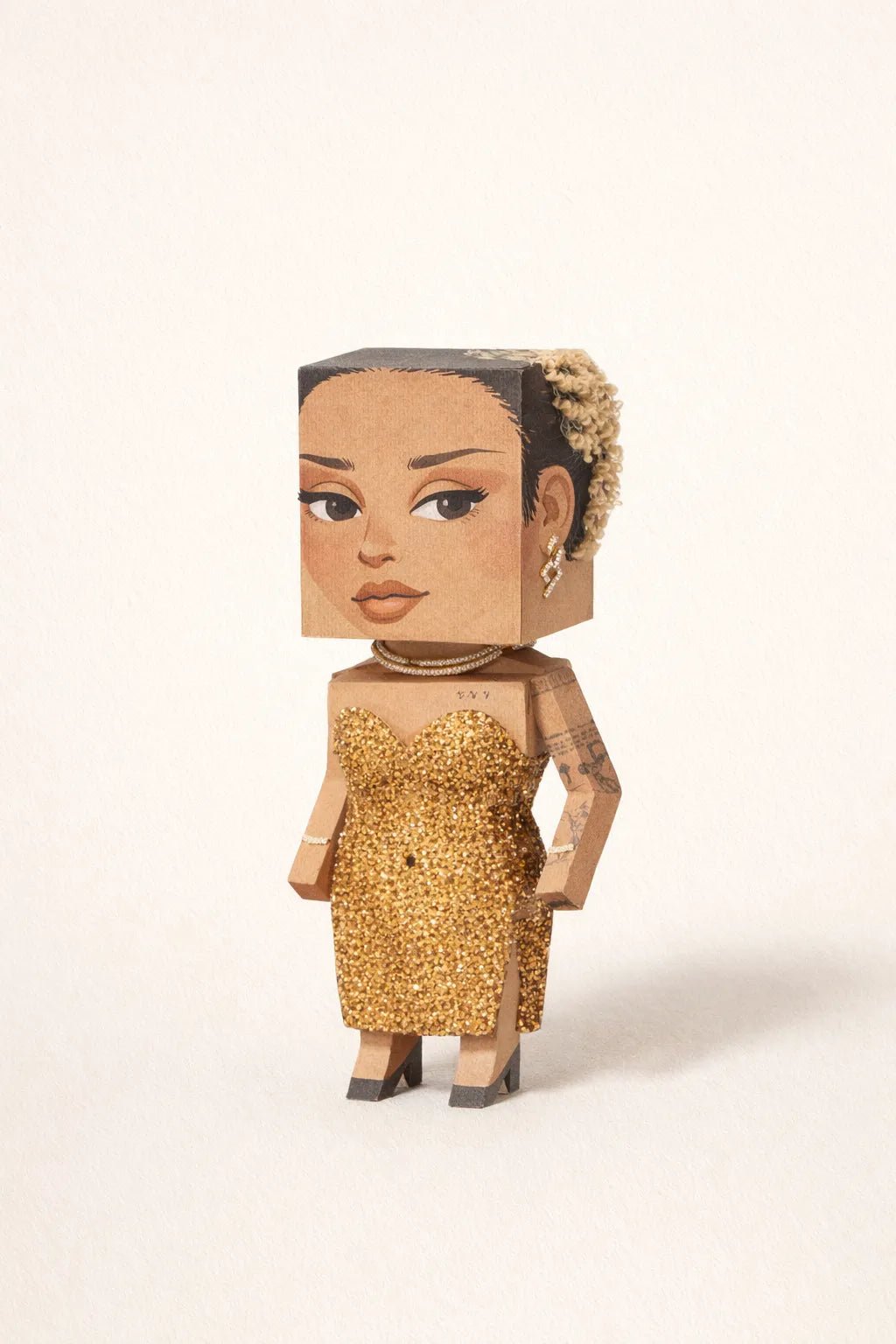 Cube-headed cardboard paper toy character on colorful studio background, showing photo-to-figure style with clean negative space: Doja Cat