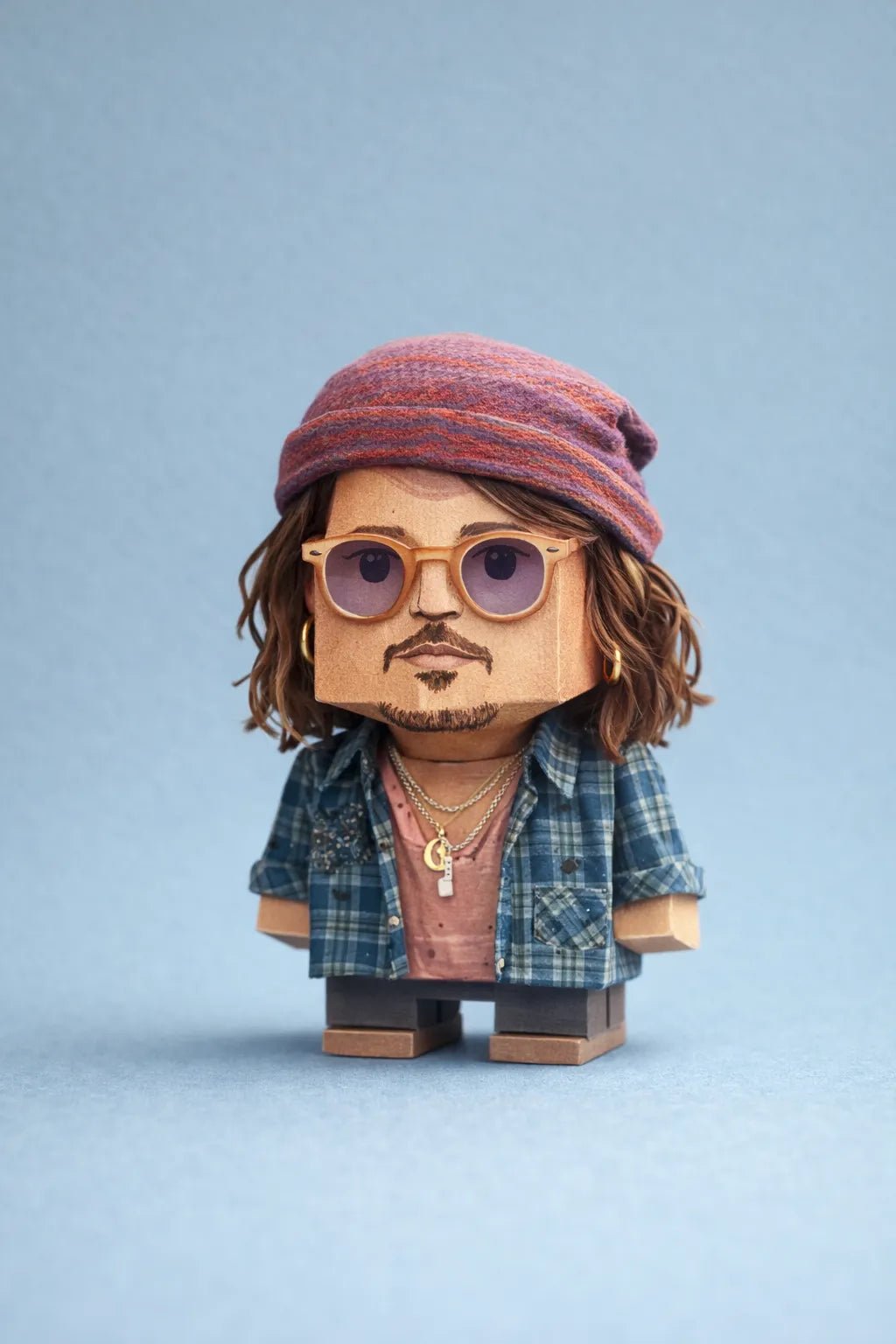 Cube-headed cardboard paper toy character on colorful studio background, showing photo-to-figure style with clean negative space: Jhonny