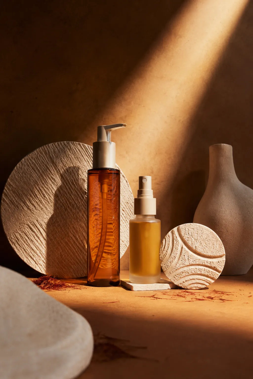 Example output from the Editorial Beauty Product Photos ChatGPT prompt: a luxury editorial skincare product photo with dramatic sunlight, sculptural shadows and a minimalist arrangement of jars and bottles styled with botanicals.