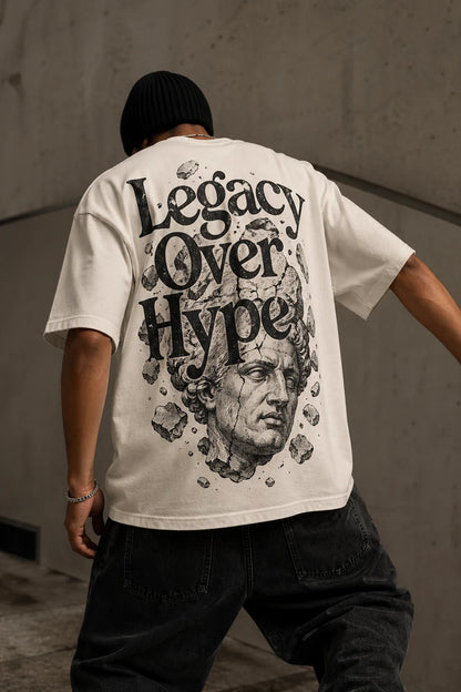 Example output from the Heritage Back Print Tee Designs ChatGPT prompt: a cream oversized tee with a Legacy Over Hype back print featuring a shattered classical marble bust.