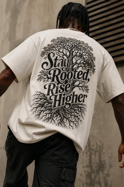 Example output from the Heritage Back Print Tee Designs ChatGPT prompt: a cream oversized tee with a Stay Rooted Rise Higher back print featuring an engraved tree and root system.