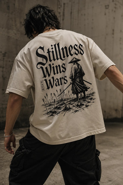 Example output from the Heritage Back Print Tee Designs ChatGPT prompt: a cream oversized tee with a Stillness Wins Wars back print featuring a lone samurai in a field.