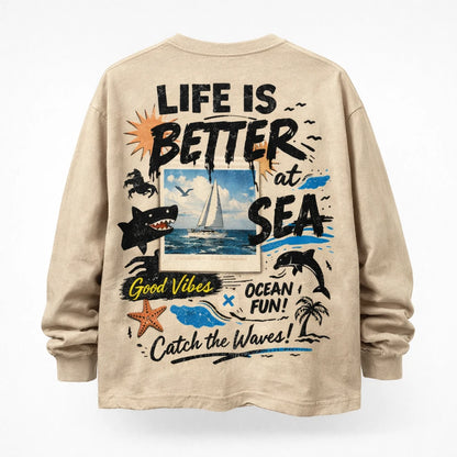 Naive Chaos Longsleeve Shirt Design. Oversized long sleeve back-graphic mockup featuring chaotic mixed-media collage, layered typography, bold icons, and screen-print texture: Life is Better at Sea