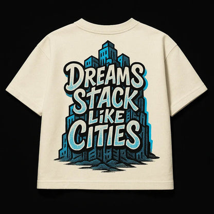 Example output from the Oversized Streetwear T Shirts Back Art ChatGPT prompt: bold graphic T-shirt mockups with screenprint-style back quotes, flat-lay perspective, and expressive pop-style illustrations on cotton fabric. Dreams Stack Like Cities.